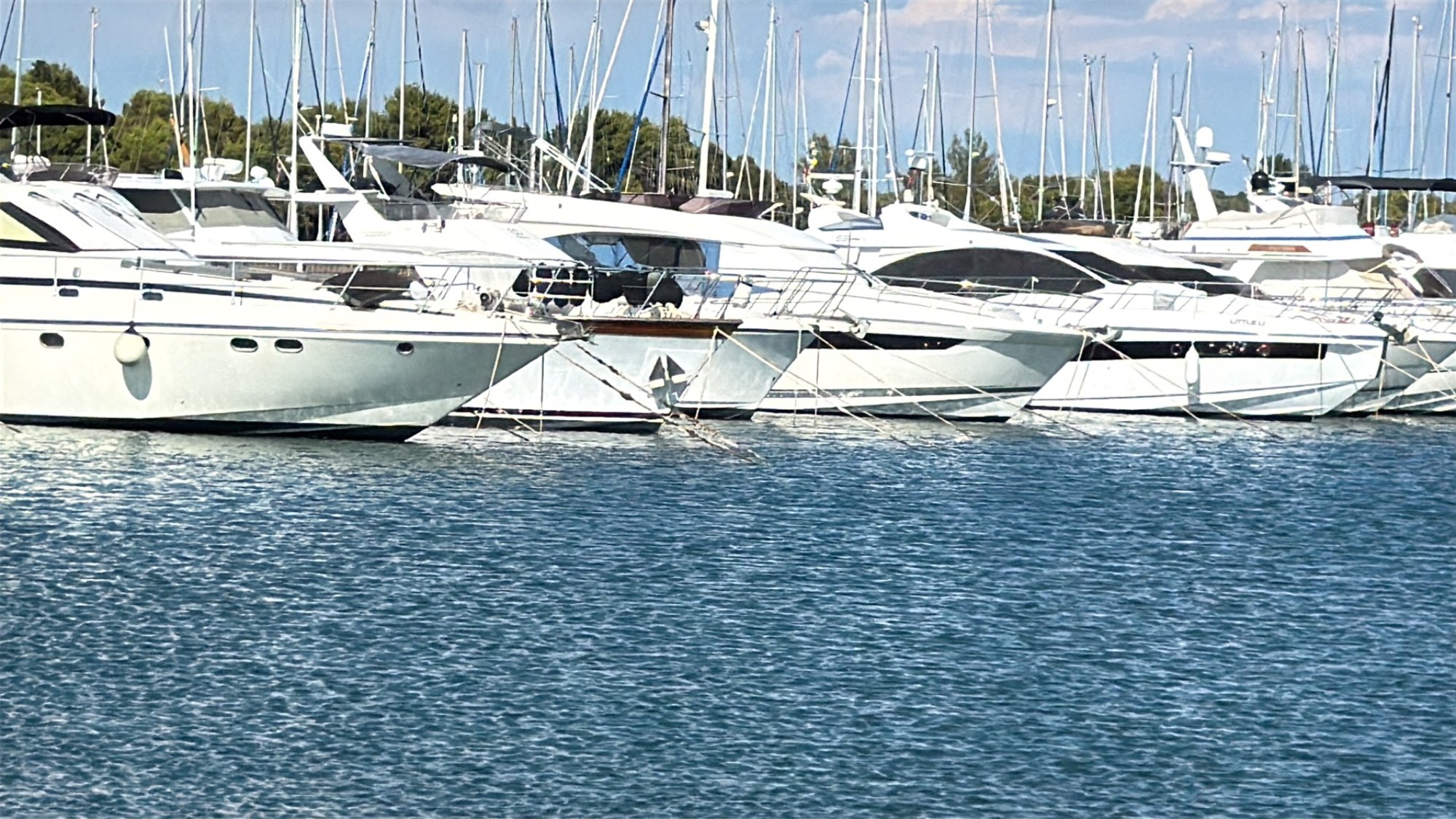 Il pontile e le barche di Marina Polesana visti dalla spiaggia